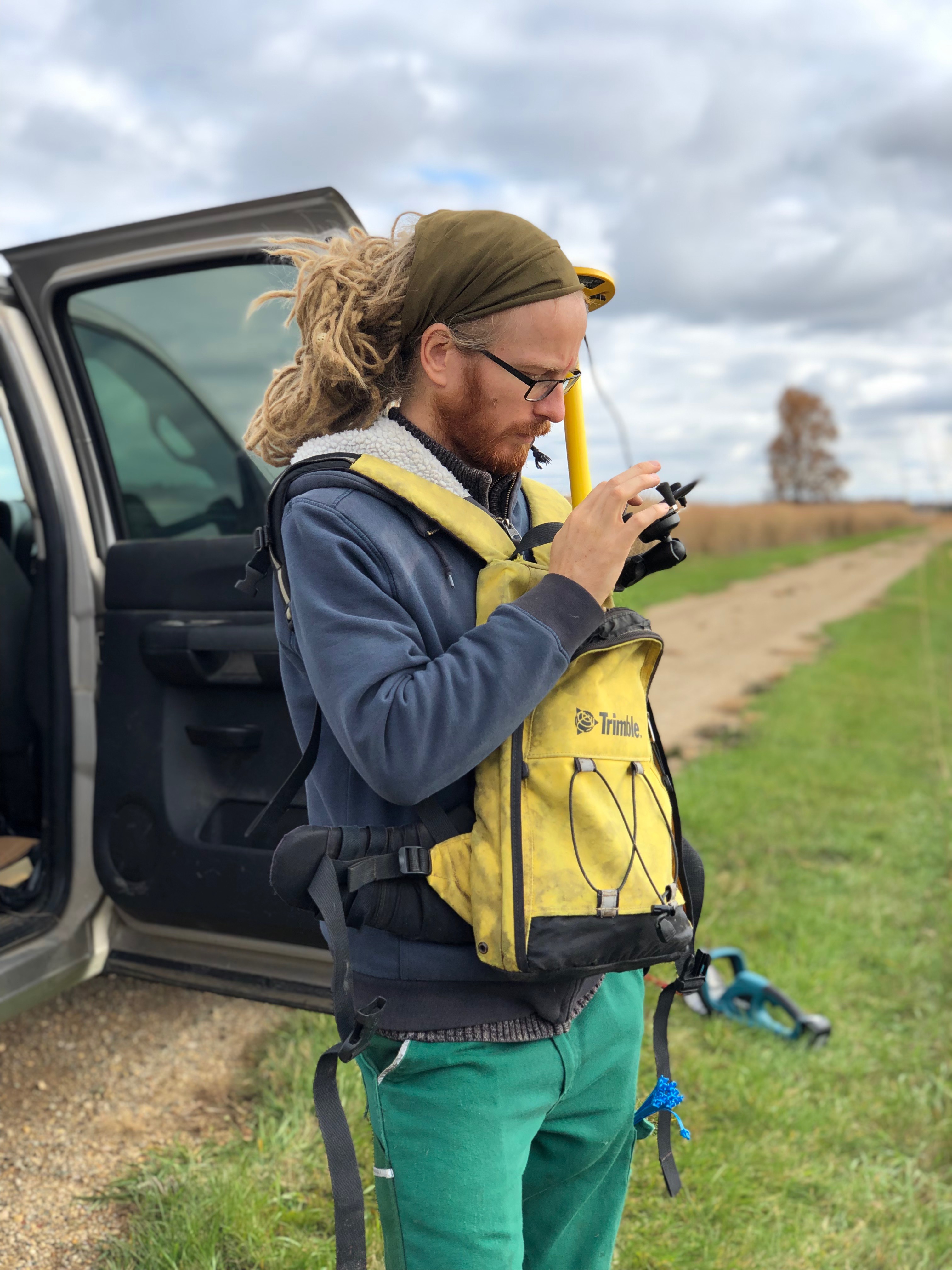 Ruben using hand-held GPS for locating points to hand-sample switchgrass